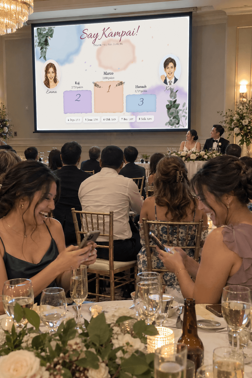 Guests at a reception look at the big screen showing the Say Kampai podium